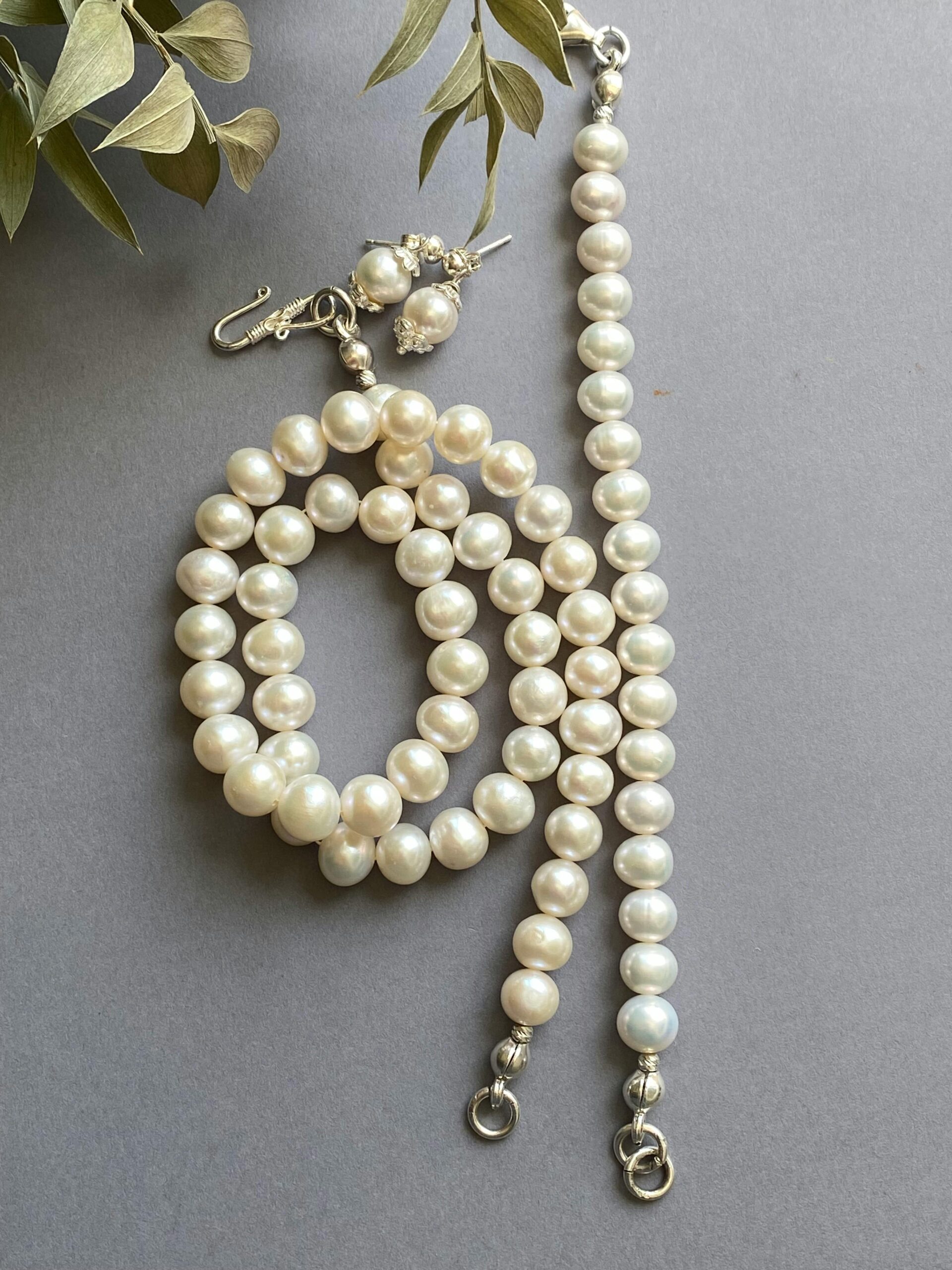Luxurious pearl necklace and earrings set with elegant silver clasps.