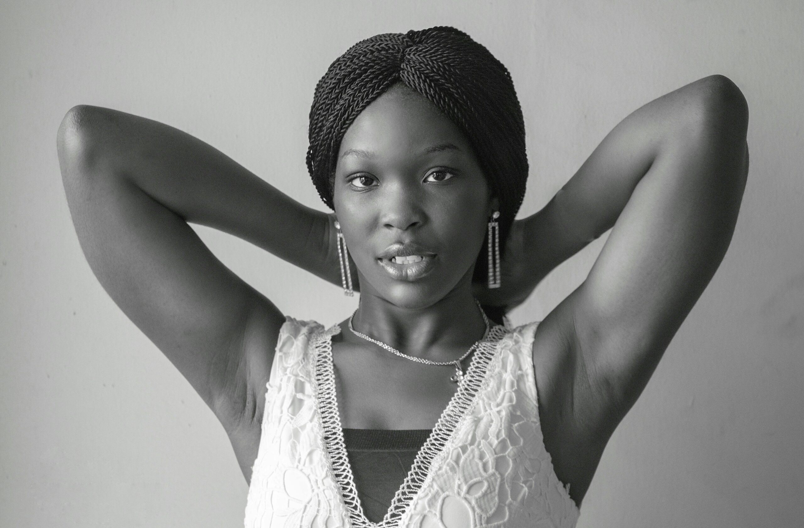 Elegant black and white portrait of a confident African woman with cornrows in Lagos, Nigeria.